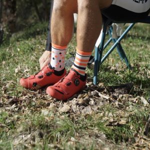 sportif chaussant des chaussures de vélo avec le modèle lucifer, chaussettes de sport dépareillées pour le trail running cyclisme