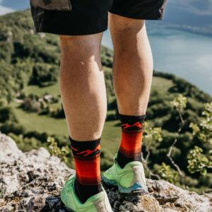 sportif en montagne avec des chaussettes sport techniques et respirantes rouges et noires les raymondes pour le trail-running