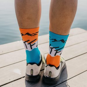 coureur portant des chaussettes de sport les raymondes techniques ultra respirantes grâce au tricotage ciblée et fit parfait pour limiter les frottement modèle WTF orange bleu orange